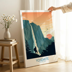 Hand holding Yosemite National Park canvas print with sunset and waterfall art in modern room