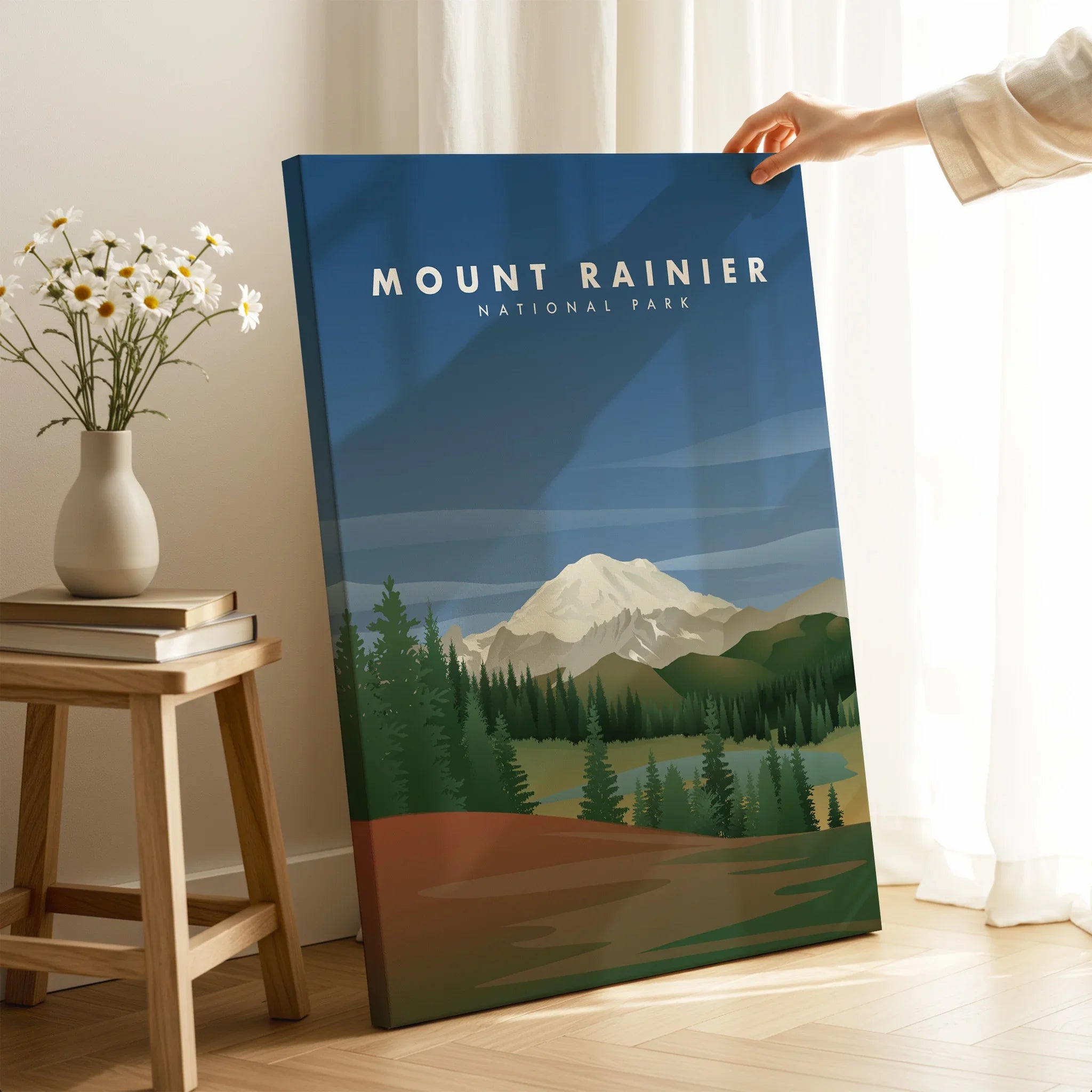 Hand holding Mount Rainier National Park canvas print in modern home decor setting
