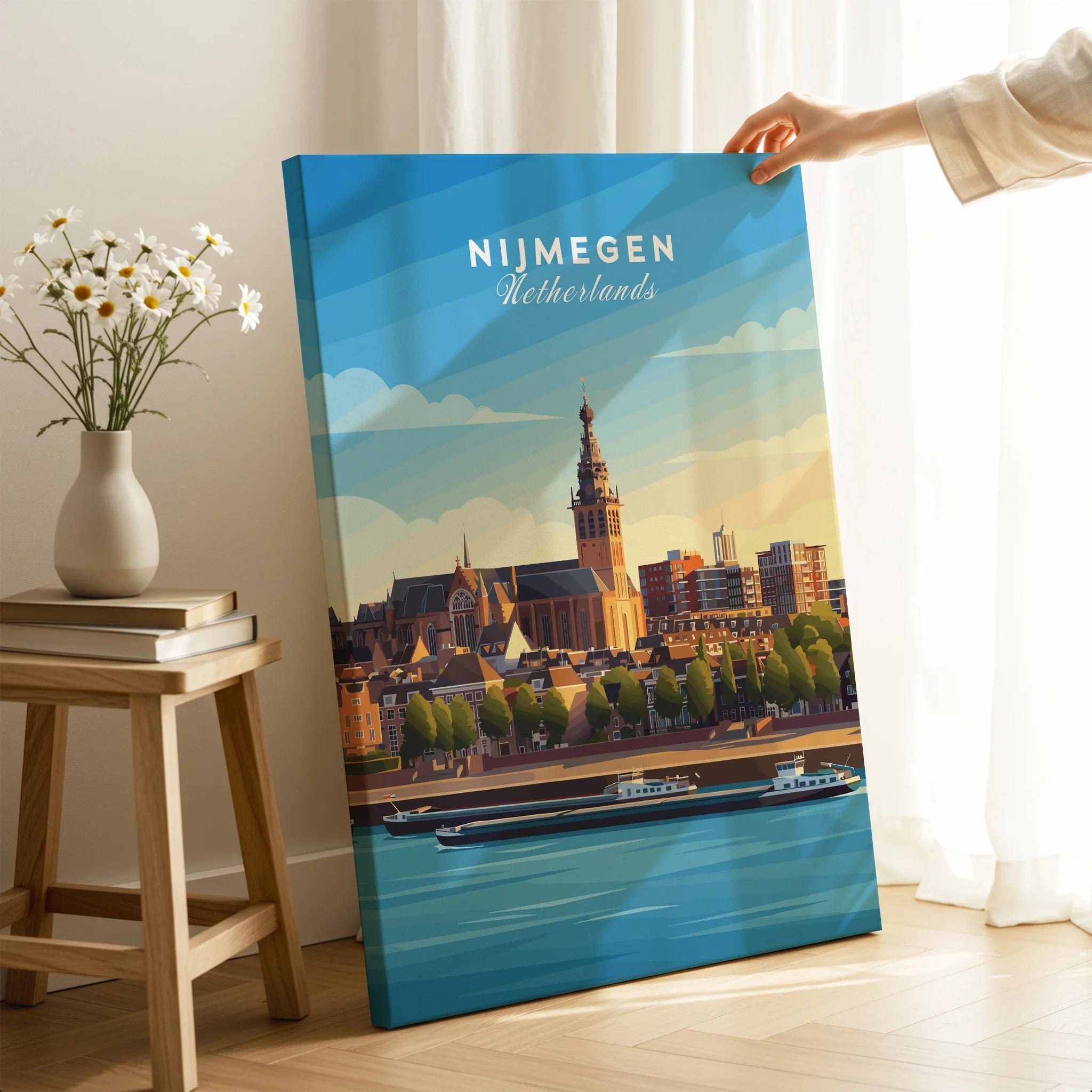 Hand holding Nijmegen Netherlands skyline canvas print in modern room setting with flowers and books