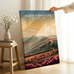 Hand holding North York Moors National Park travel poster in bright, modern room