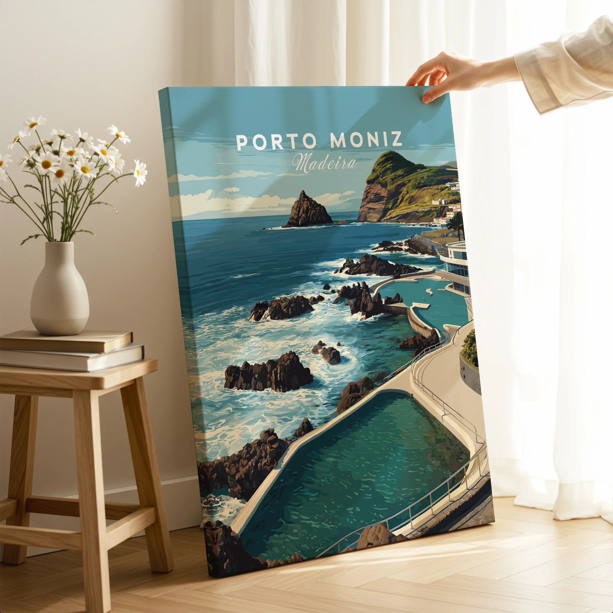 Hand holding Porto Moniz Madeira travel poster canvas print in modern home interior setting