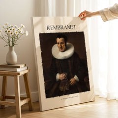 Rembrandt Old Lady with Book 1637 Portrait Print Dutch Golden Age Poster Art displayed on a wall with flowers.
