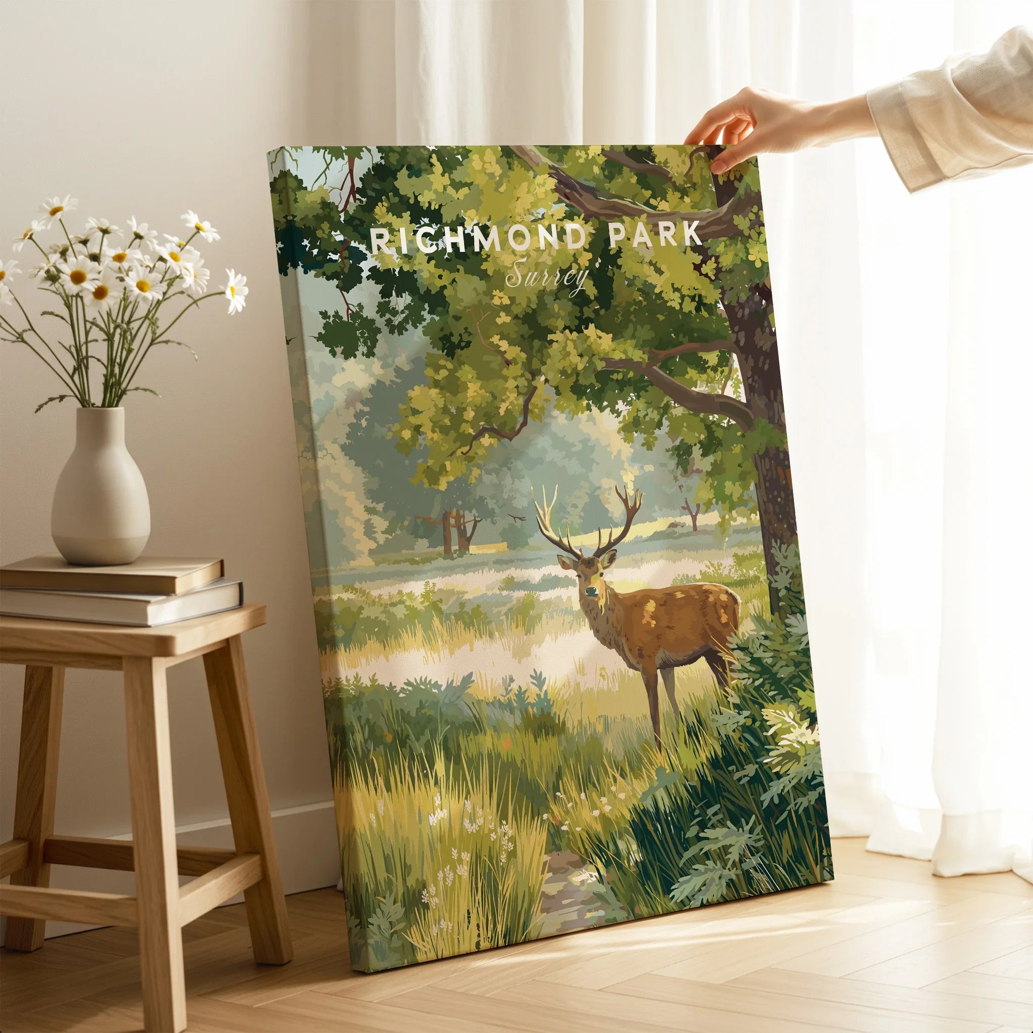 Richmond Park canvas print with stag artwork, hand holding it in bright living room