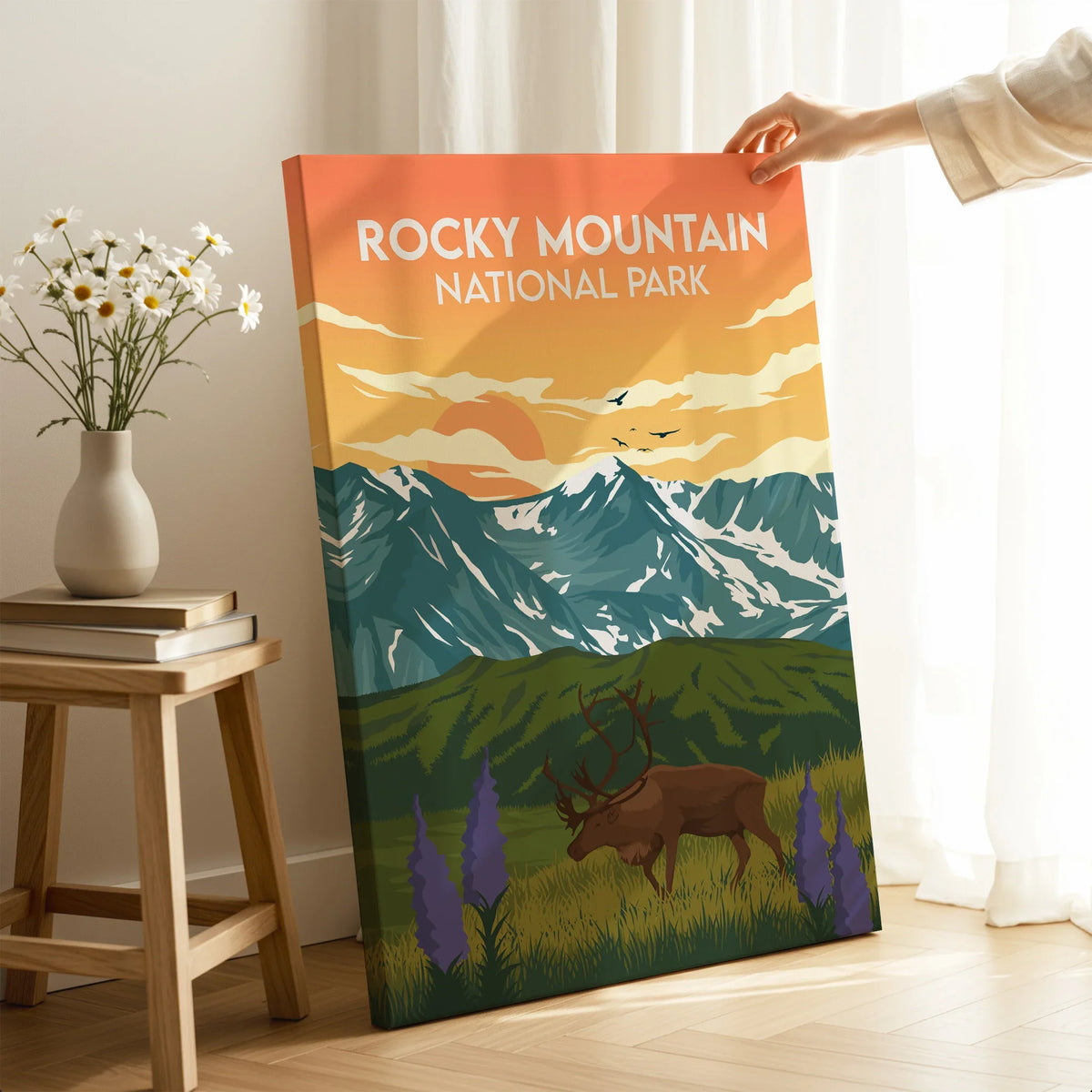 Rocky Mountain National Park canvas print with elk and mountain landscape, hand holding artwork in modern room
