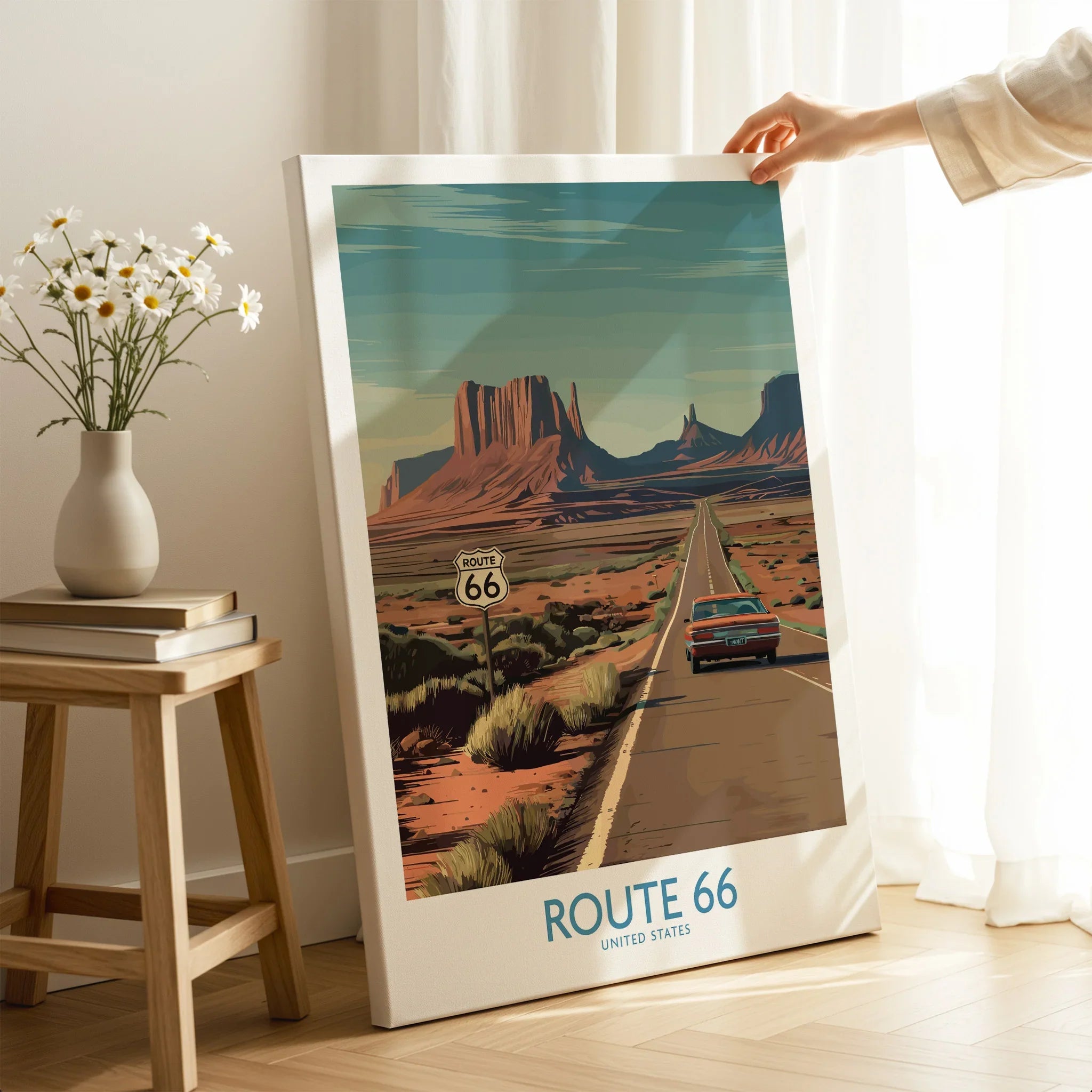 Route 66 wall art print with car driving desert highway, hand holding canvas in cozy room