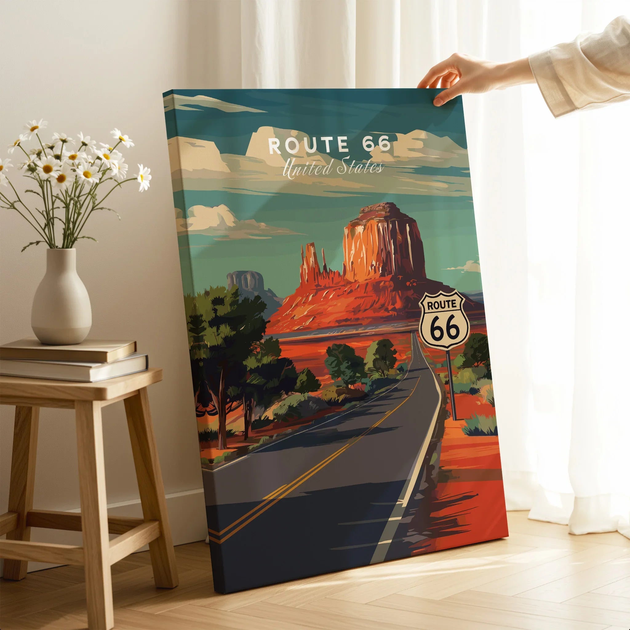 Hand holding Route 66 canvas wall art poster with desert landscape in a modern room setting