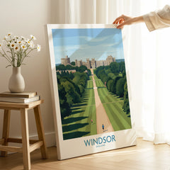 Hand holding Windsor England travel poster print in bright modern home interior