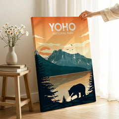 Hand holding Yoho National Park travel poster print with bear silhouette, mountains, and sunset.