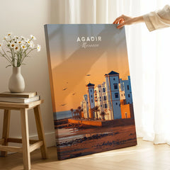 Agadir Travel Poster – Morocco Beach Print on stretched canvas with mirror-wrap edges, held by hand in a room setting