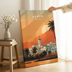 Agadir Travel Poster – Moroccan Mosque and Desert Sunset Art on stretched canvas with mirror-wrap edges, held by hand in a room setting