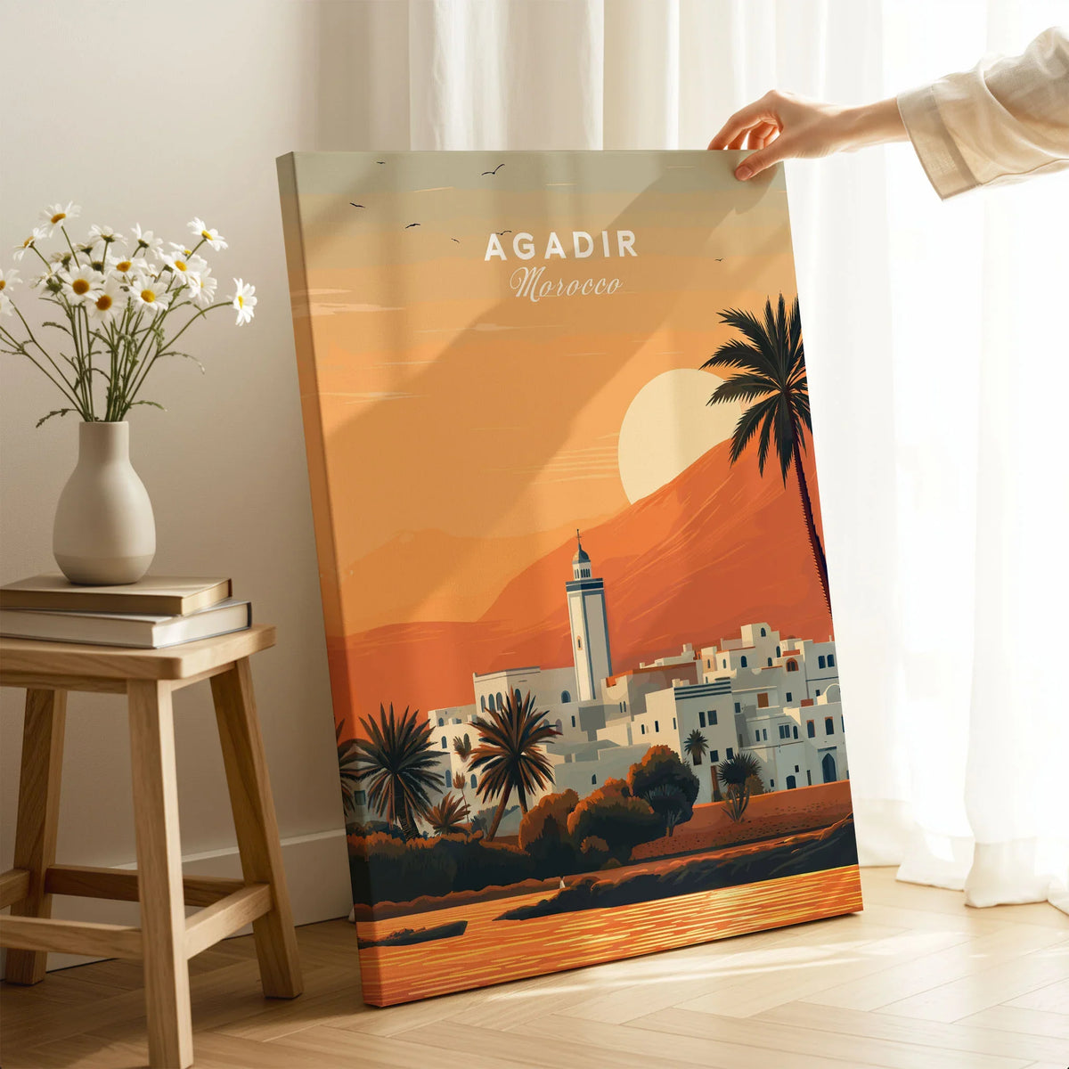 Agadir Travel Poster – Moroccan Mosque and Desert Sunset Art on stretched canvas with mirror-wrap edges, held by hand in a room setting
