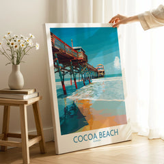 Cocoa Beach Pier Poster - Florida Beach Travel Decor on stretched canvas with mirror-wrap edges, held by hand in a room setting