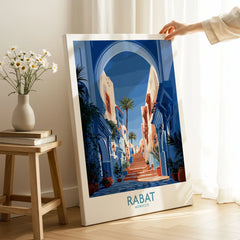 Rabat Morocco Blue Alleyway Wall Art — a blue-washed medina lane and stone steps seen through a horseshoe arch, shown as canvas print mirror edge hand holding room setting