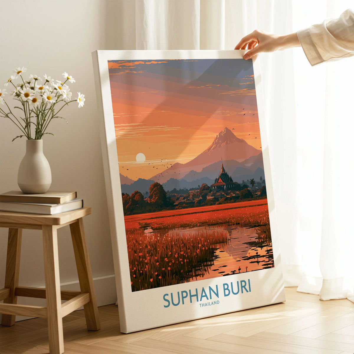 Suphan Buri Thailand Temple Sunset Wall Art — a lotus-covered lake and temple spire at sunset beneath a mountain peak, shown as canvas print mirror edge hand holding room setting