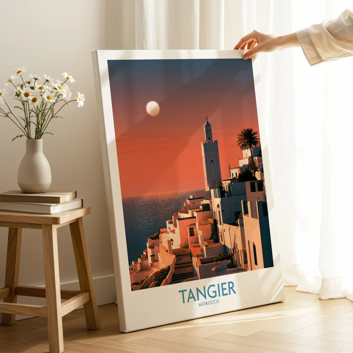 Tangier Morocco Coastal Sunset Wall Art — a whitewashed hillside town and minaret glowing above the sea at sunset, shown as canvas print mirror edge hand holding room setting