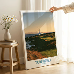 Turnberry Scotland Rocky Shore Wall Art — the Turnberry lighthouse above a rocky shore with the Arran hills beyond, shown as canvas print mirror edge hand holding room setting