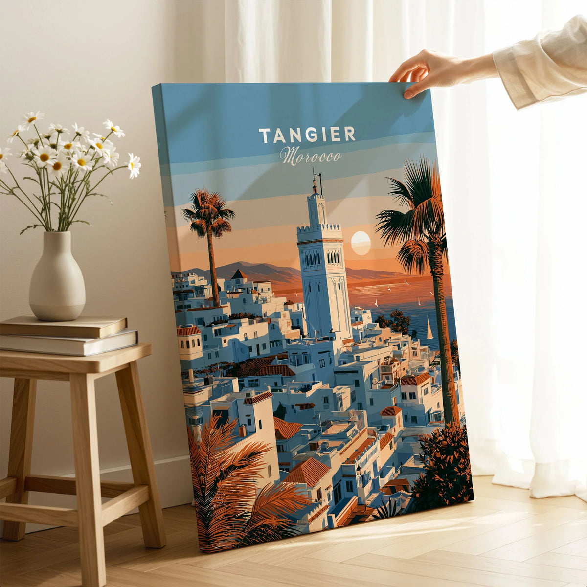 Tangier Morocco Sunset Medina Travel Poster — Tangier medina rooftops and a minaret above a bay dotted with sails, shown as canvas print mirror edge hand holding room setting