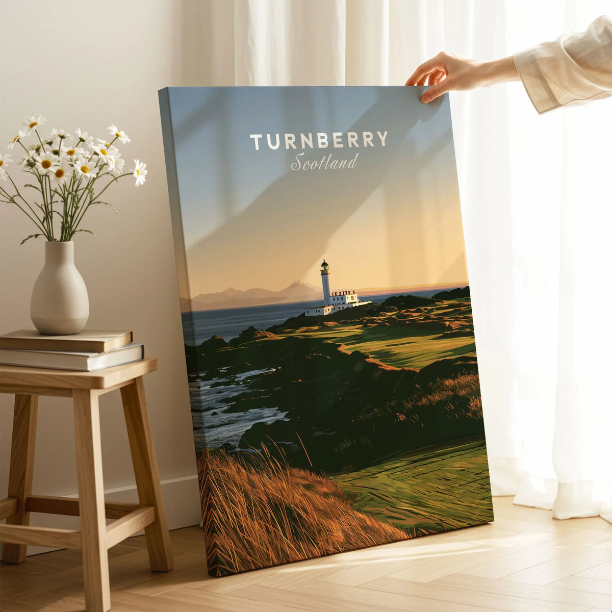 Turnberry Scotland Lighthouse Travel Poster — the Turnberry lighthouse above a rocky shore with the Arran hills beyond, shown as canvas print mirror edge hand holding room setting