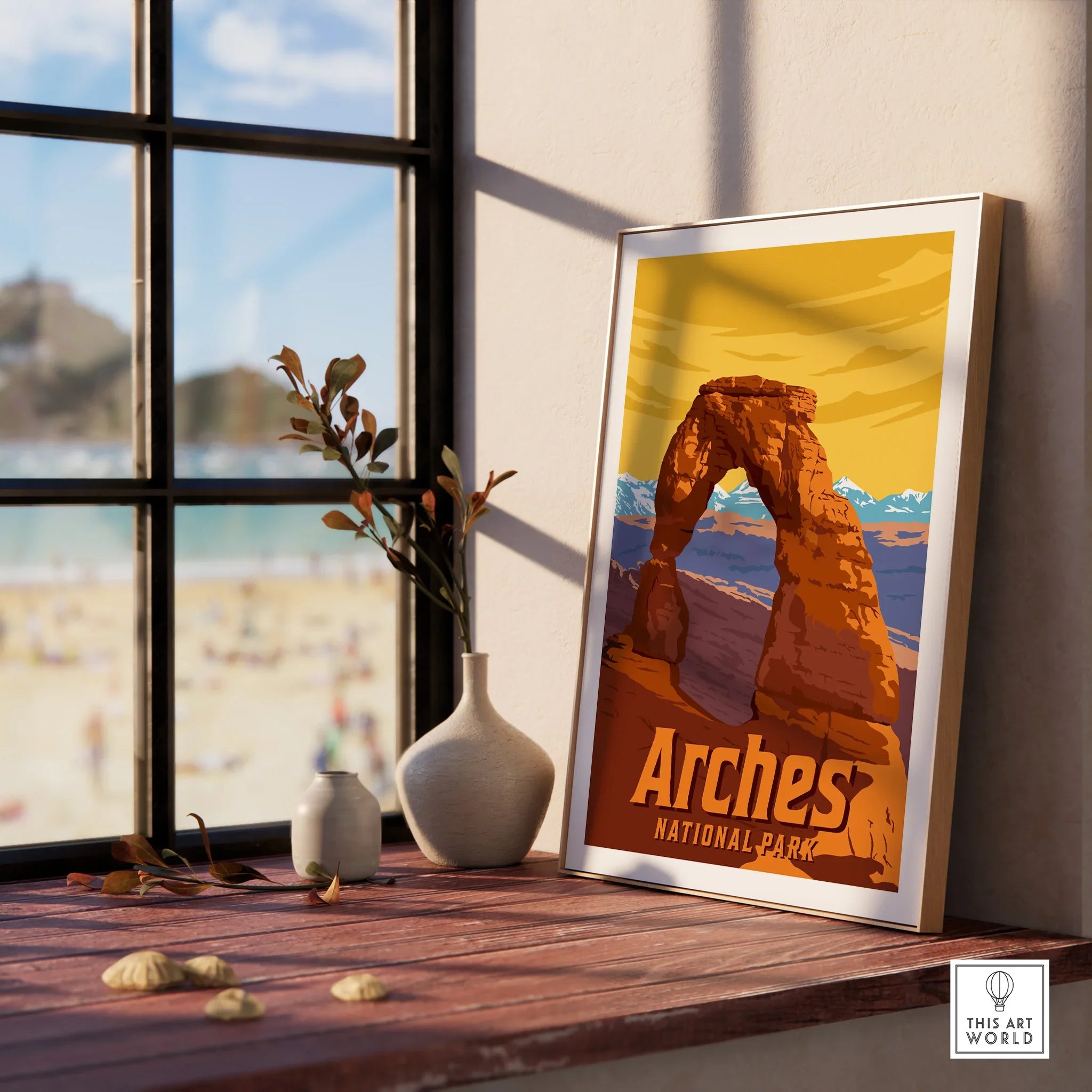 Framed Arches National Park print on windowsill with vases and beach view outside window