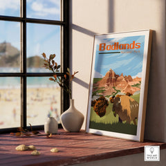 Framed Badlands National Park print with bison, set on sunlit windowsill with vases.