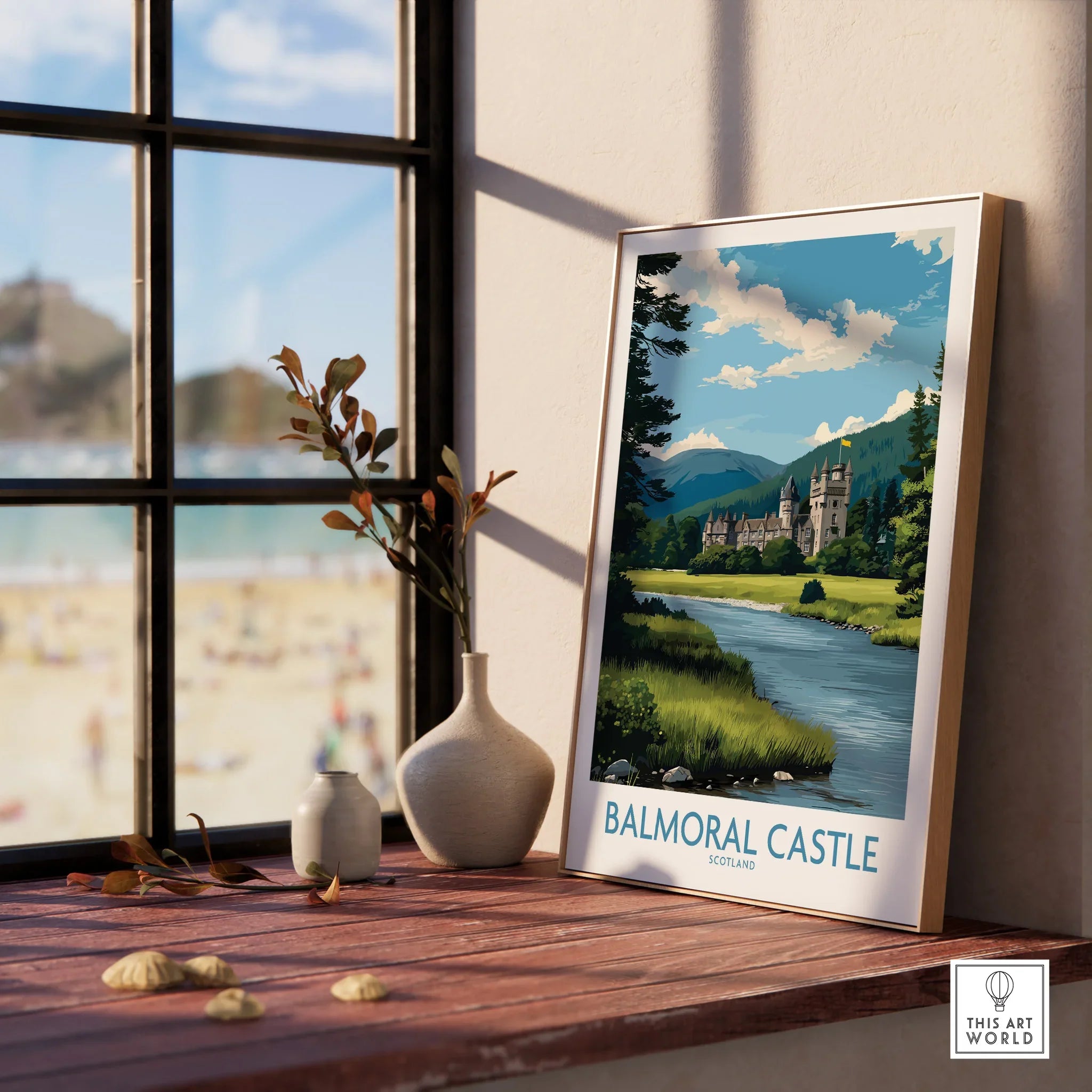 Framed Balmoral Castle travel print with vases on a windowsill, beach scene outside window.