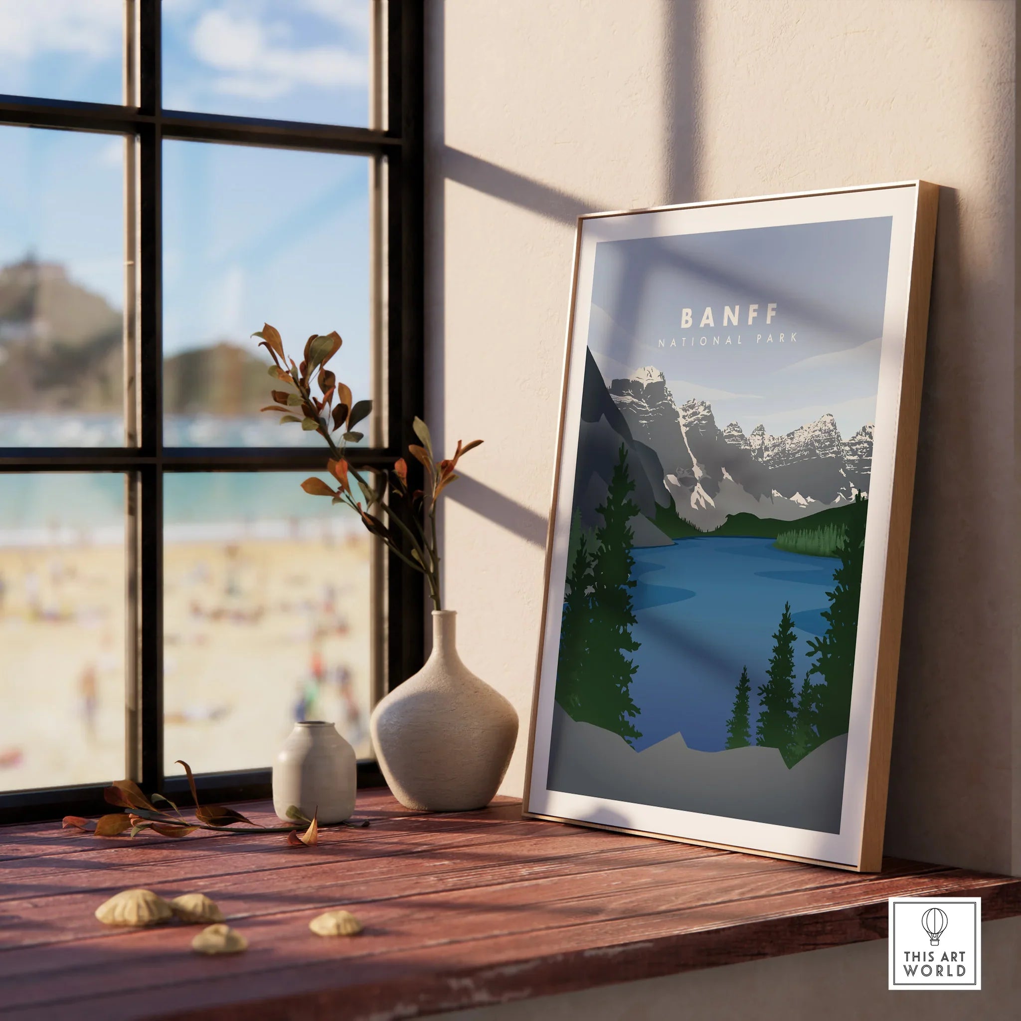 Framed Banff National Park art print with mountains and lake, displayed on a windowsill.
