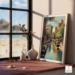 Framed Birmingham city canal wall art print on a windowsill with vases and beach view