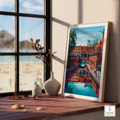 Framed Birmingham travel poster on windowsill with vases and beach view in background