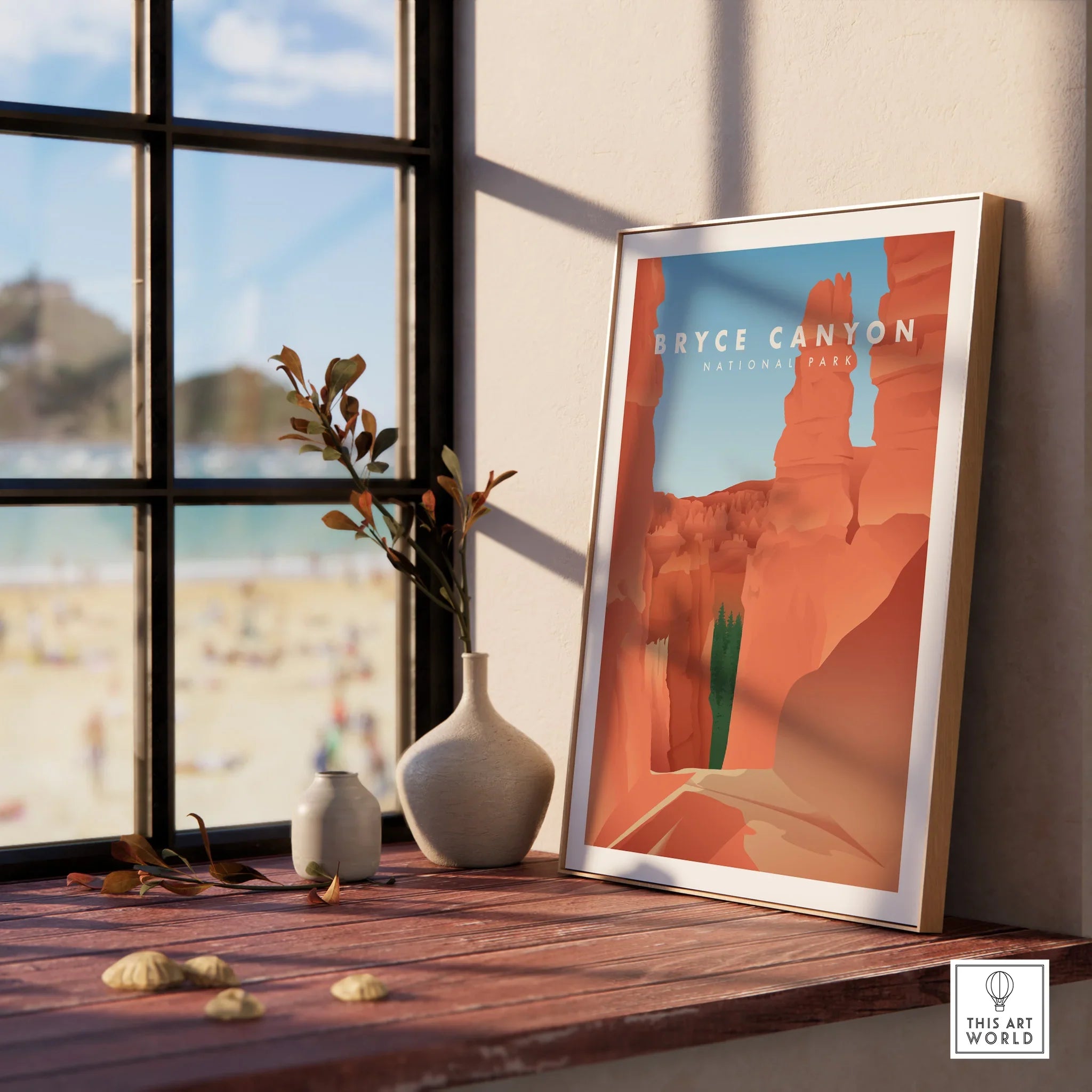 Framed Bryce Canyon National Park print on windowsill with vases and beach view outside.