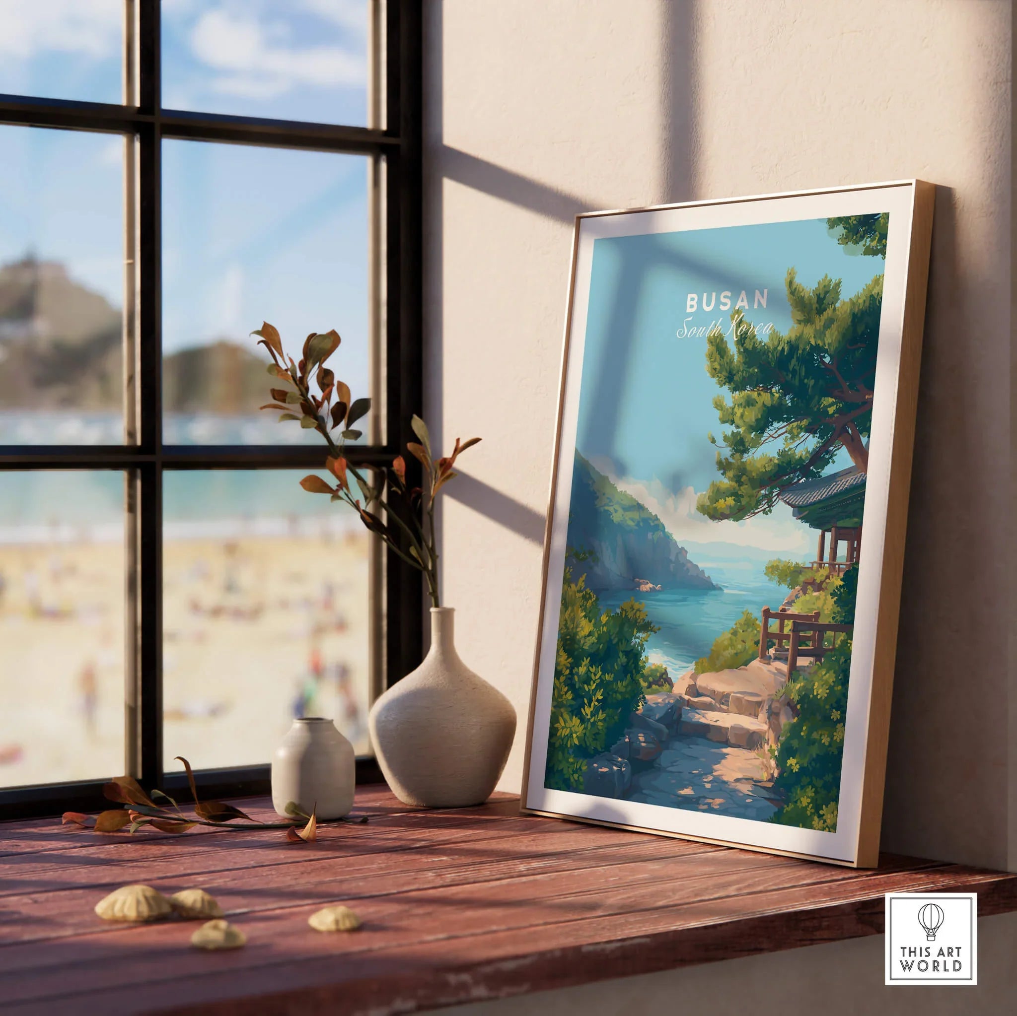 Framed Busan travel poster on window ledge with beach and vases, natural wood frame