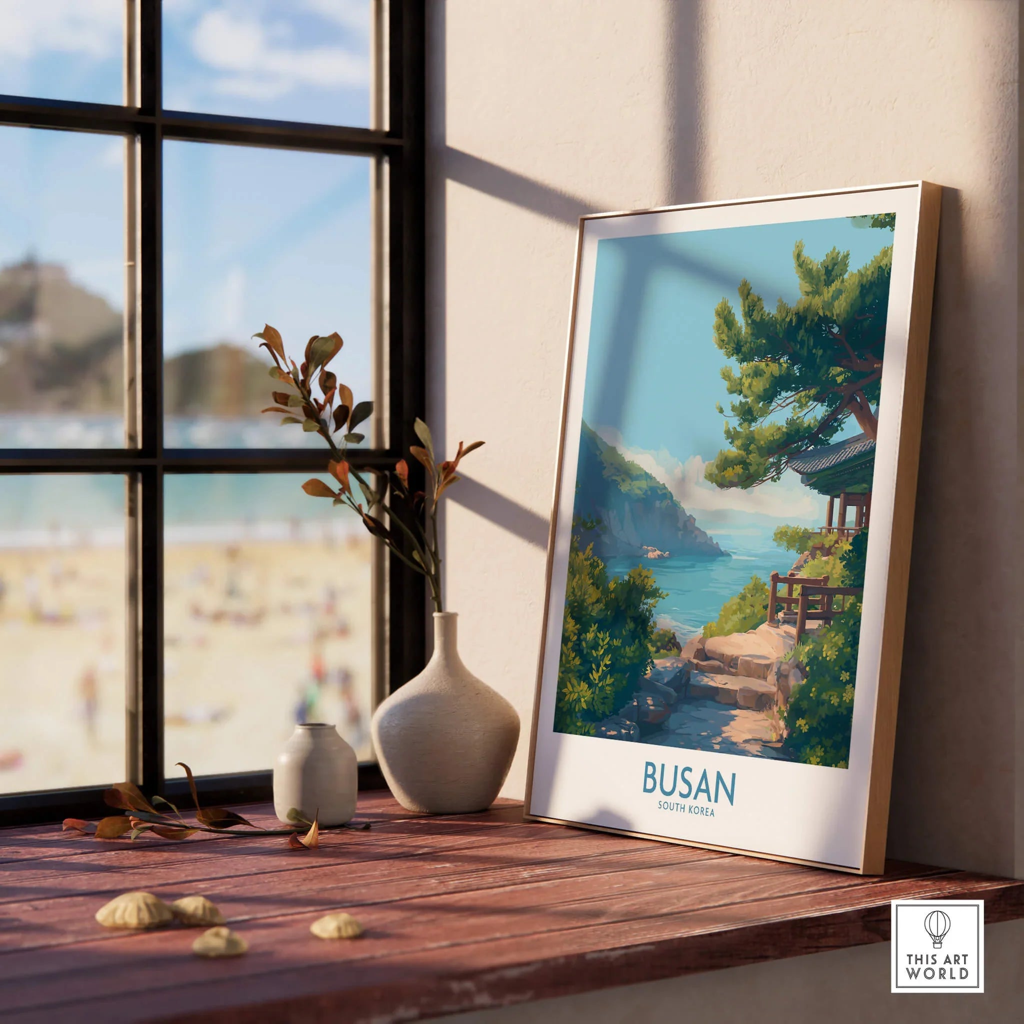 Framed Busan travel poster with coastal art, natural wood frame on sunny windowsill