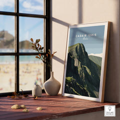 Framed Cadair Idris Wales travel poster on a windowsill with natural light and beach view