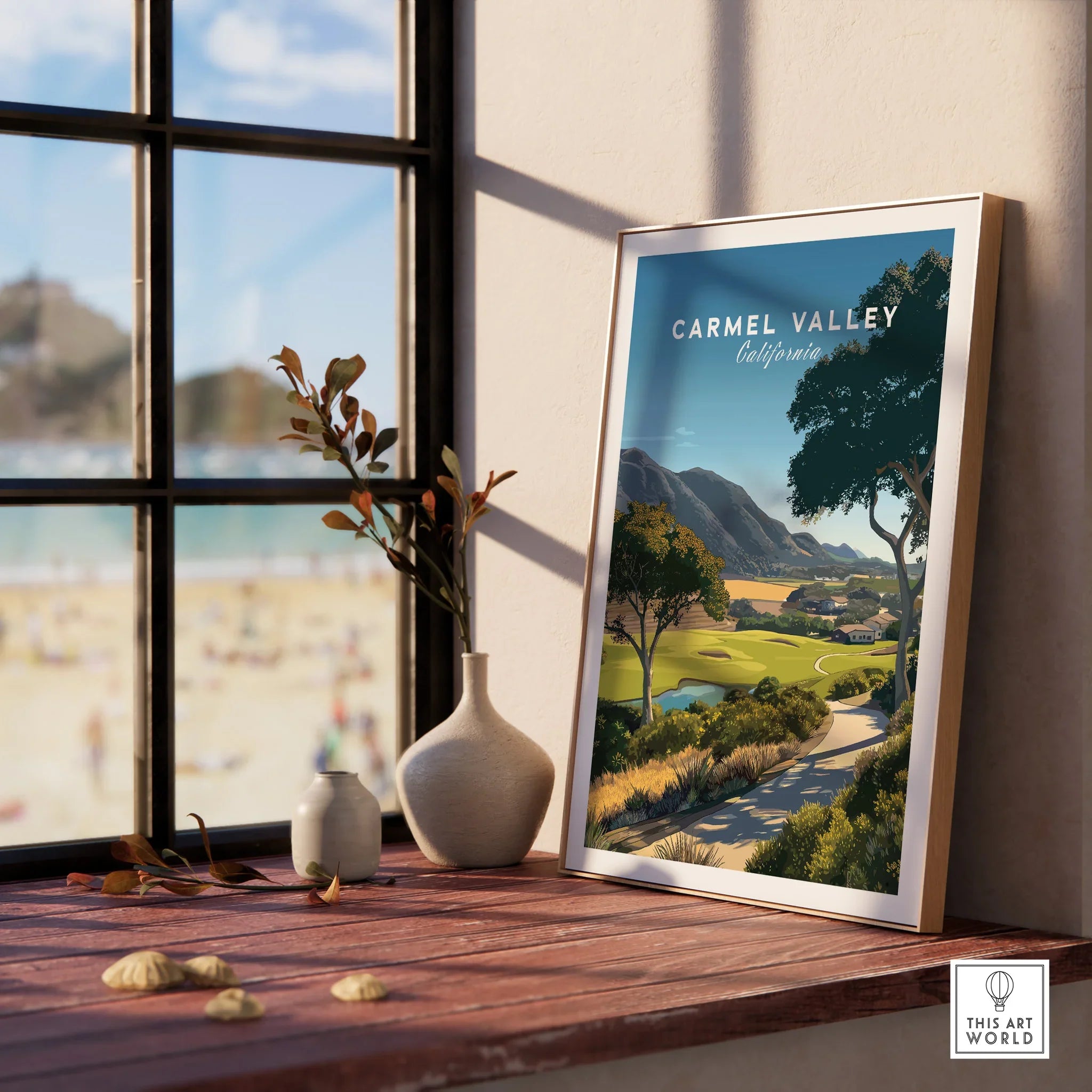 Framed Carmel Valley California travel poster on windowsill with natural light and vases.
