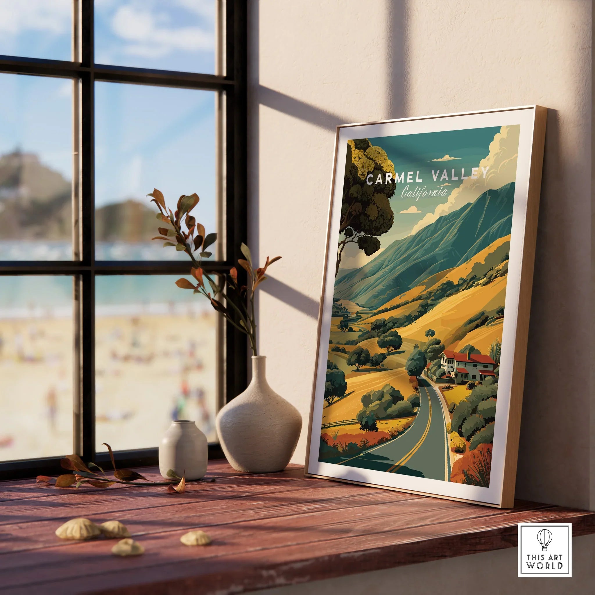 Framed Carmel Valley California travel poster on wood shelf by sunlit window, vases nearby