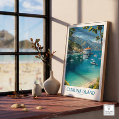 Framed Catalina Island travel poster with beach and boats, displayed on a sunny windowsill.