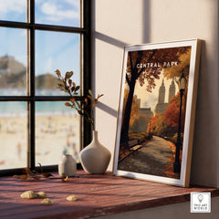 Framed Central Park New York art print on windowsill with autumn trees and skyline.
