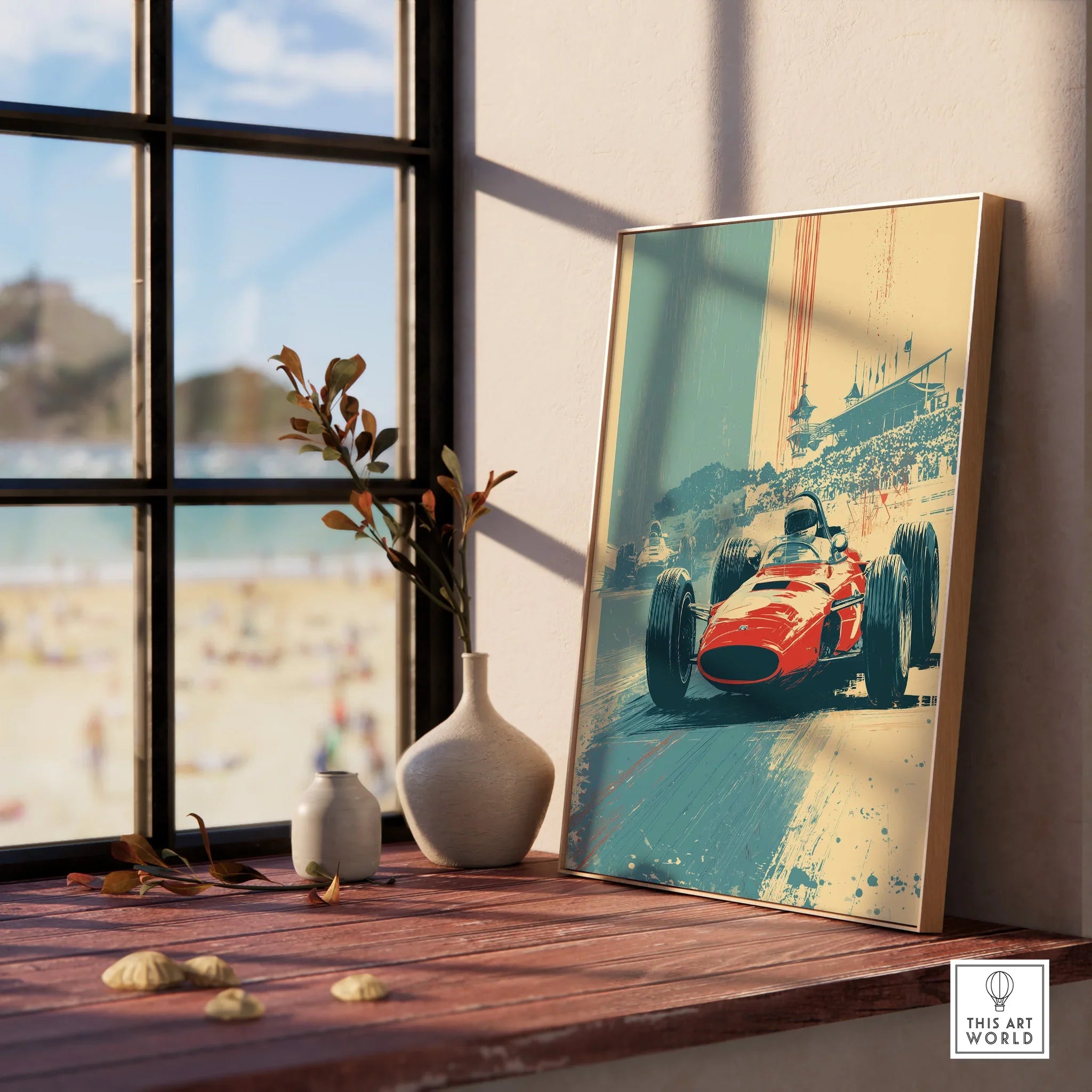 Framed racing car wall art print on wooden windowsill, beach view in background