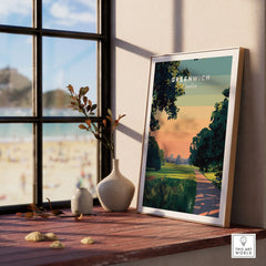 Framed Greenwich London travel poster on sunny window ledge with vases and outdoor view.