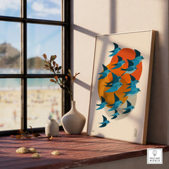 Framed art print of blue birds with orange sun on window sill, modern home decor