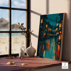 Framed Japan street art print with lanterns, natural wood frame on windowsill, coastal view