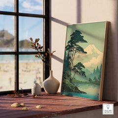 Framed Japanese woodblock landscape print with mountain view on a windowsill, home decor