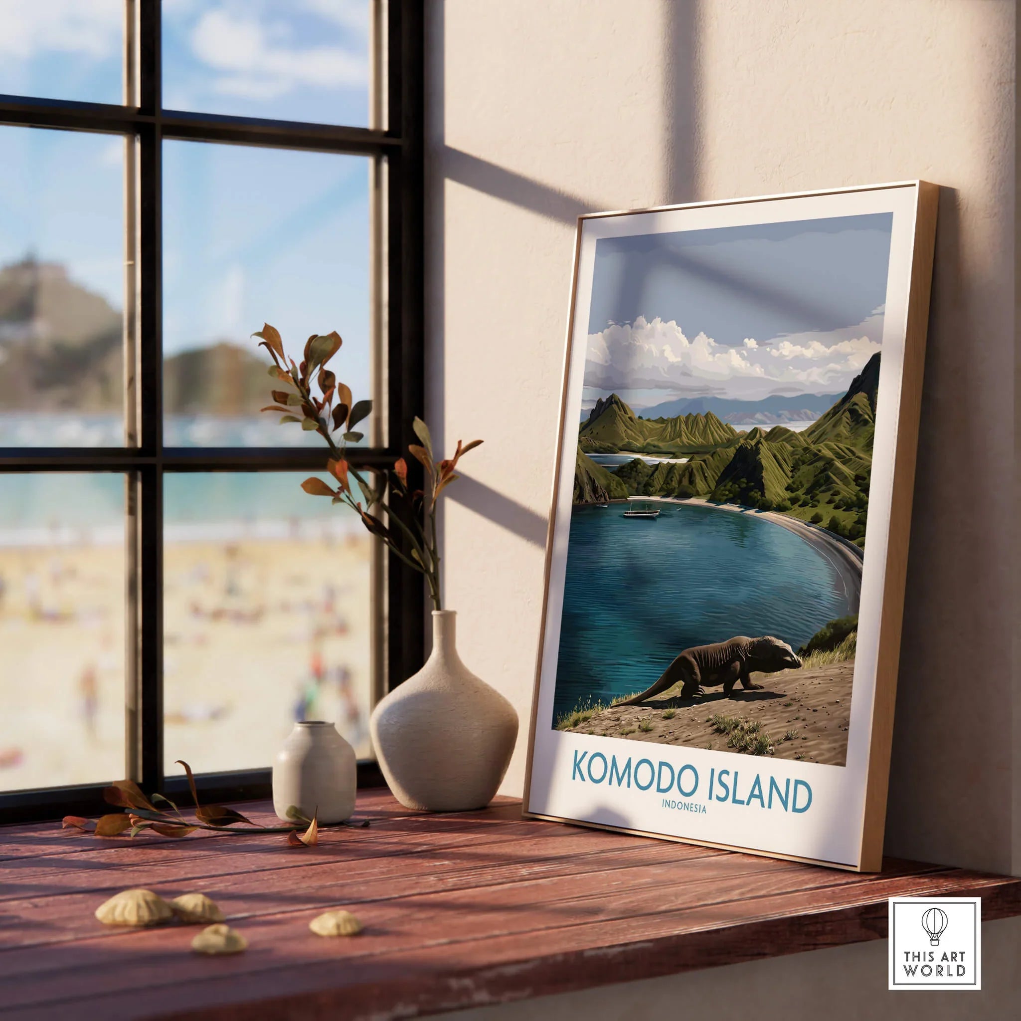 Framed Komodo Island travel art print with natural wood frame on windowsill, beach view outside