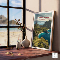 Framed Komodo Island travel poster on wooden windowsill with vases and beach view
