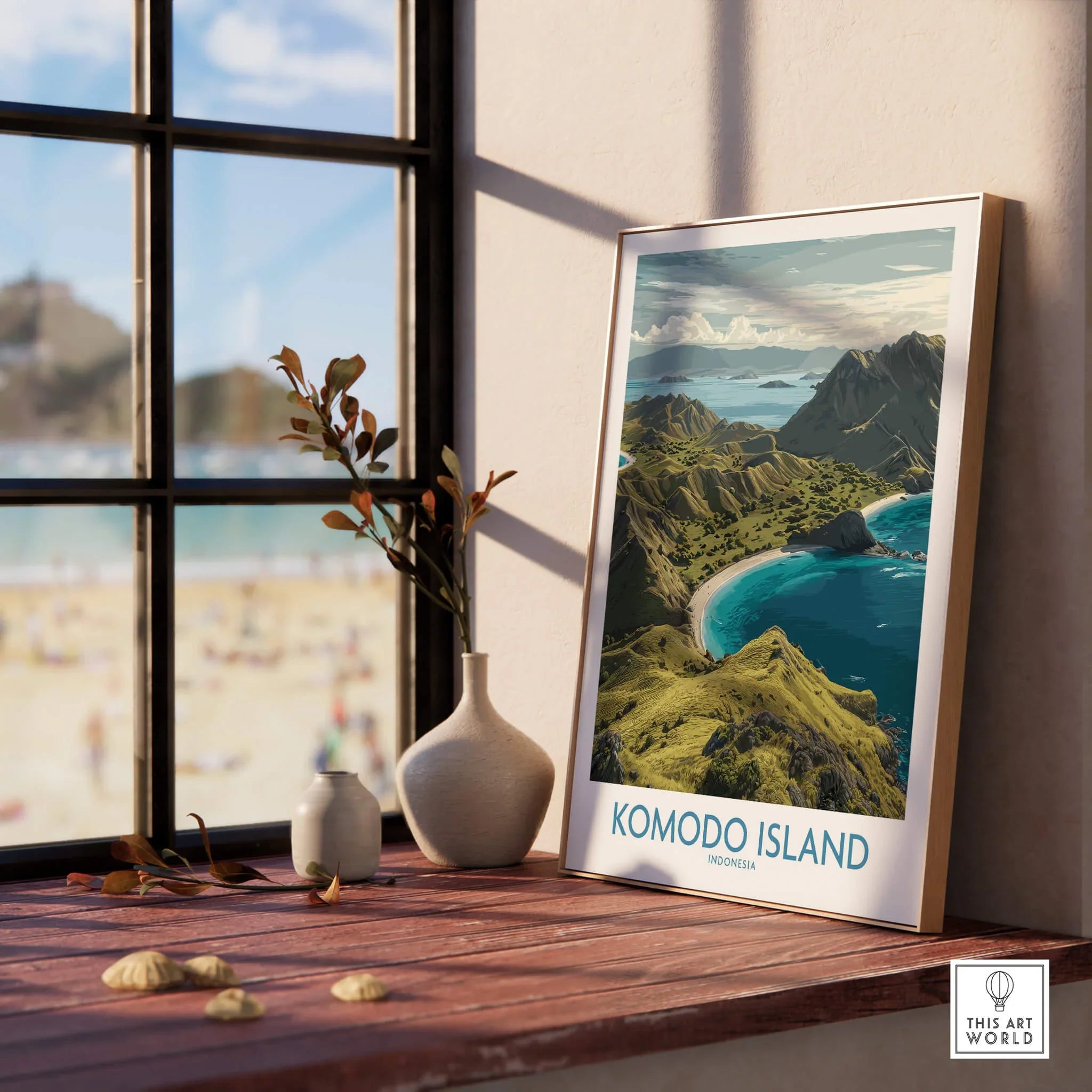 Framed Komodo Island travel poster on windowsill with natural wood frame and beach view