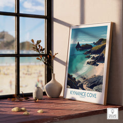 Kynance Cove Cornwall Poster | Scenic Sea Cliffs & Beach Canvas Print displayed on a wooden table near a window.