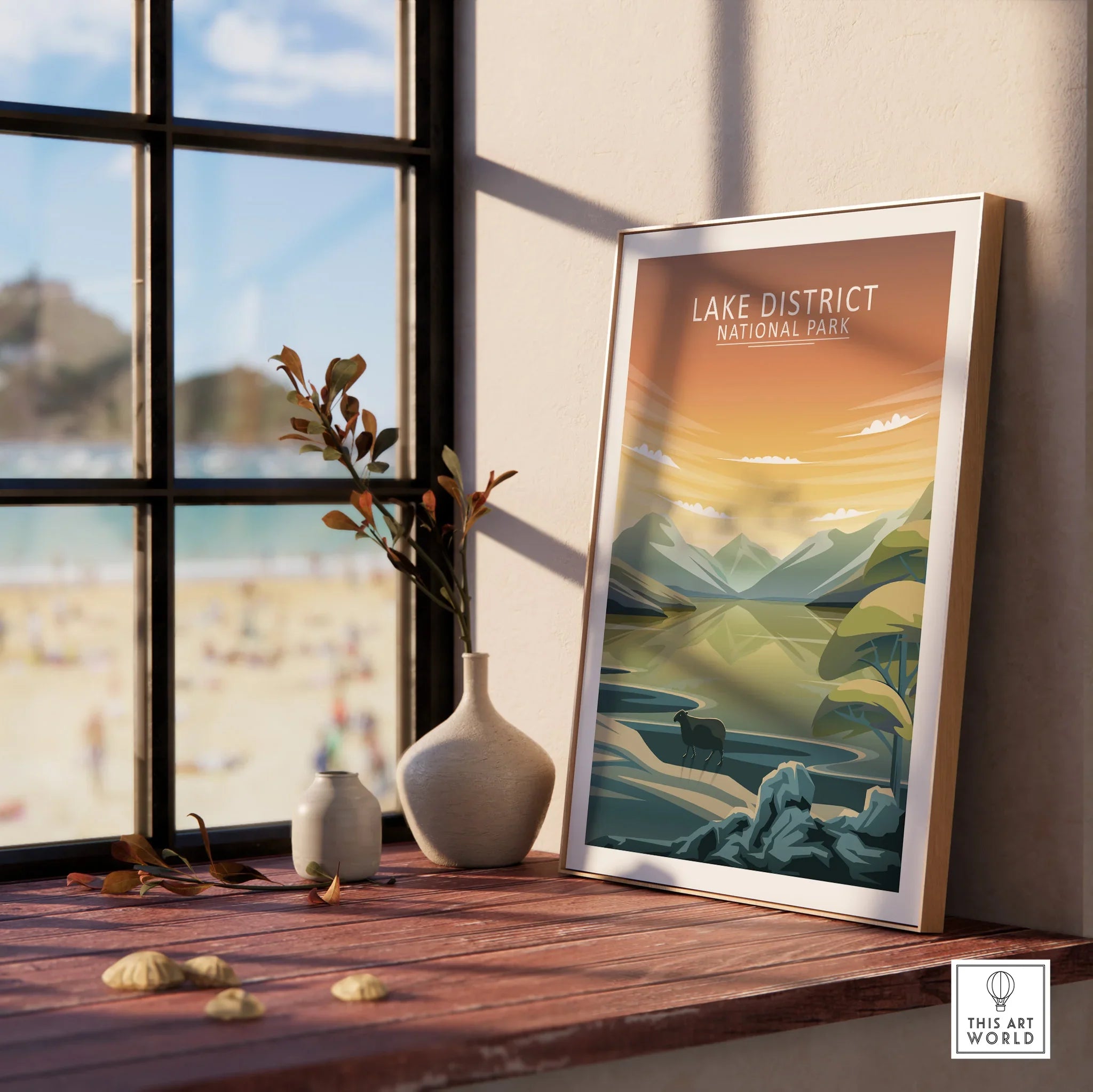 Framed Lake District National Park travel print on a windowsill with vases and plants.