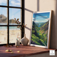 Framed Llanberis Pass Snowdonia travel poster on a windowsill with vases, scenic wall art.
