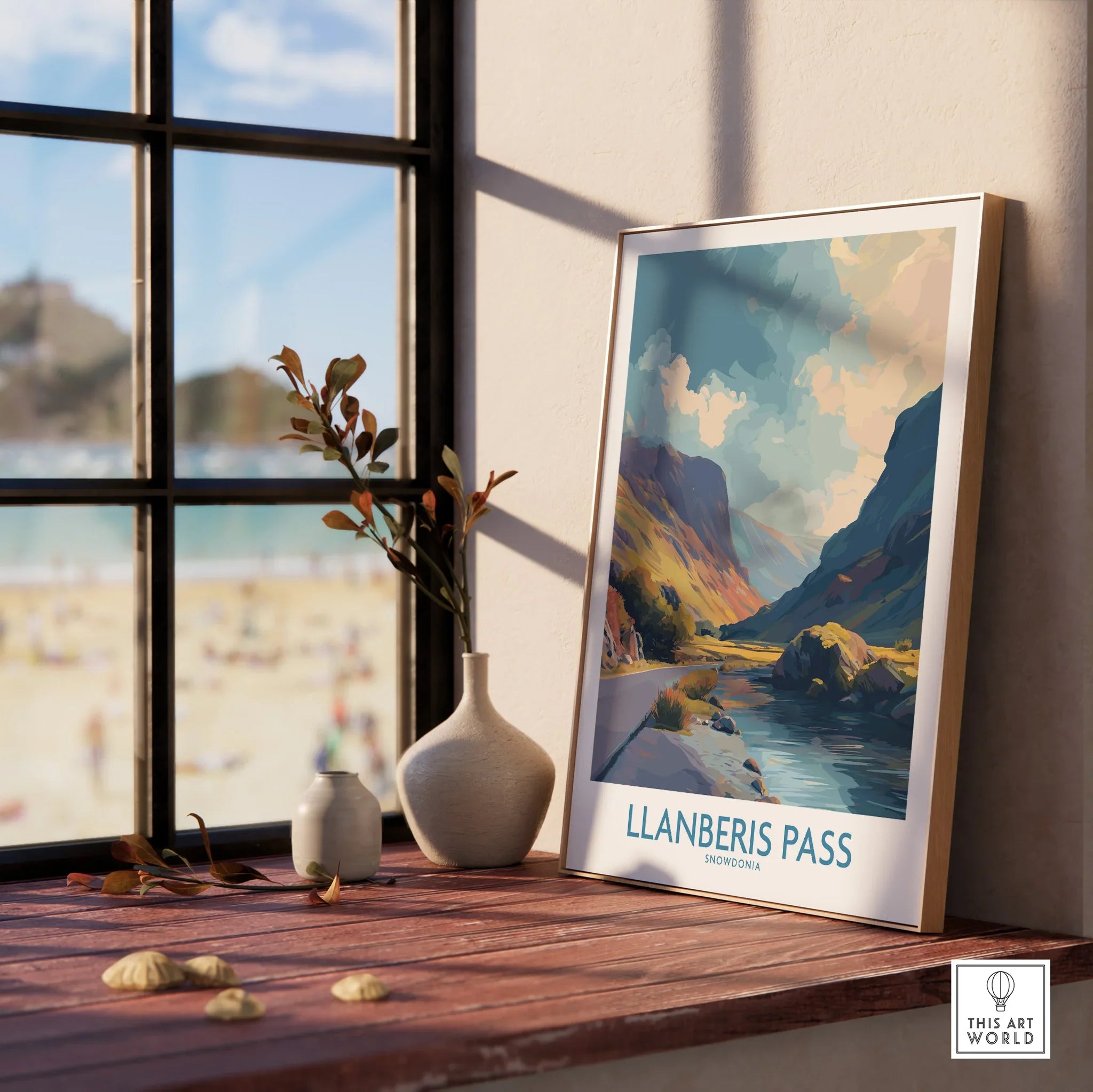Framed Llanberis Pass travel poster with scenic mountain landscape on a wooden windowsill