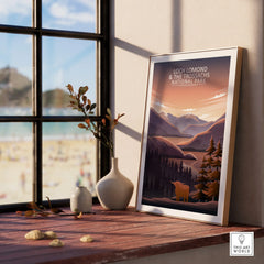 Loch Lomond travel poster in natural wood frame on windowsill, with scenic mountain art.