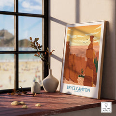 Bryce Canyon National Park print in natural wood frame on windowsill with vases, beach outside.
